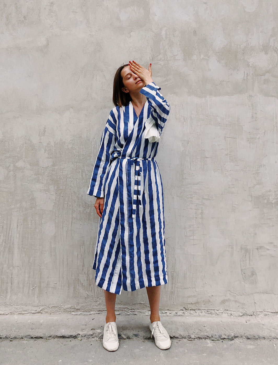 woman-in-blue-and-white-striped-dress-covering-her-left-eye-1182702